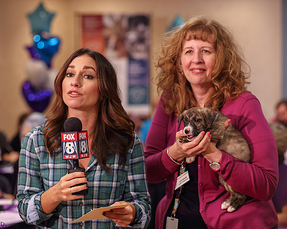 Judy Hunter holding a puppy on-air