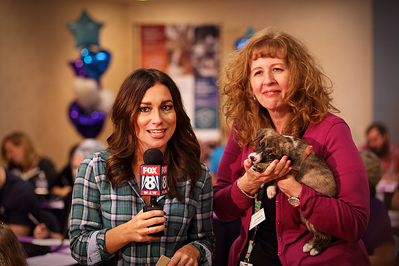 Judy Hunter holding a puppy on-air